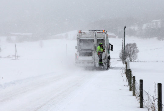 Renovasjonsbil på veien, i snø og kulde