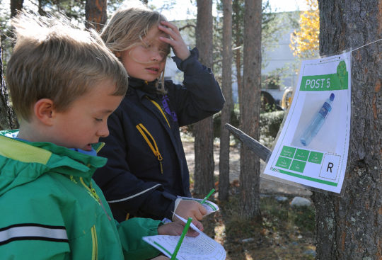 Bildet viser to skolebarn som deltar på natursti om kildesortering