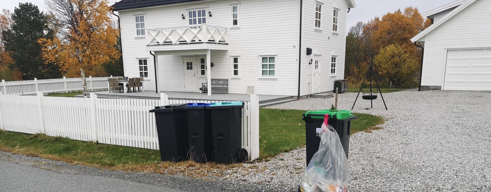 Bilde av fire dunker og sekk for plastemballasje utenfor et hus. Matavfall og plastsekk står klart for henting.